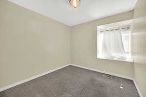 Carpeted empty room featuring baseboards