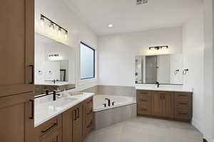 Bathroom with two vanities, a bath, recessed lighting, and light tile patterned flooring