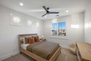 Carpeted bedroom with ceiling fan and recessed lighting