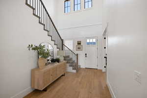 Entrance foyer featuring light wood-style floors and a high ceiling