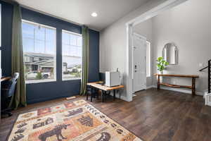 Living area featuring dark wood-type flooring and recessed lighting