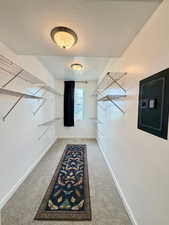 Walk in closet featuring light colored carpet