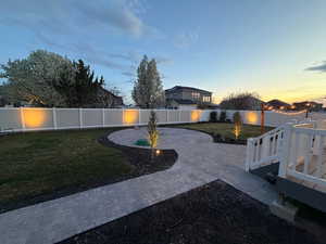Fenced backyard featuring a patio and decorative driveway