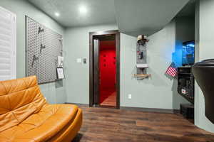 Sitting room featuring dark wood-type flooring and a textured ceiling