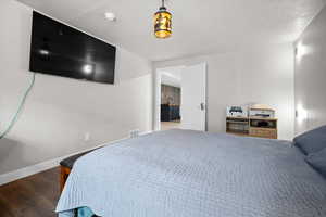 Bedroom featuring dark wood-style floors and ensuite bathroom