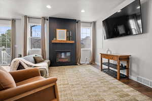 Living room featuring a fireplace, wood finished floors, and recessed lighting