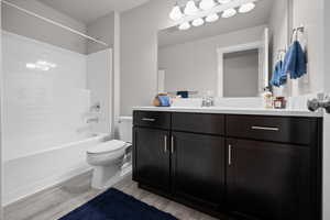 Bathroom featuring vanity, shower / bath combination, and light wood-type flooring