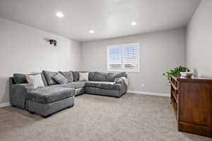 Living room with light carpet and recessed lighting