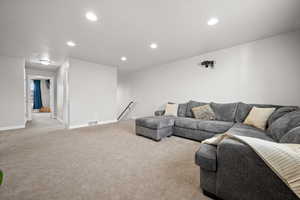 Living room with light colored carpet and recessed lighting