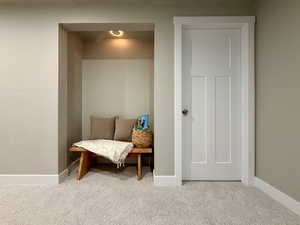 Living area featuring baseboards and light carpet