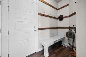 Mudroom featuring dark wood-style floors and baseboards