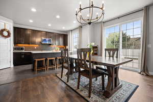 Dining space with dark wood-type flooring and hanging lights
