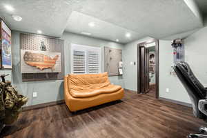 Sitting room featuring a textured ceiling, dark wood-type flooring, and recessed lighting
