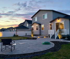 Back of house featuring a patio, a fenced backyard, stucco siding, and a wooden deck