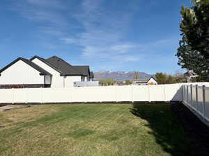 Fenced backyard featuring a mountain view