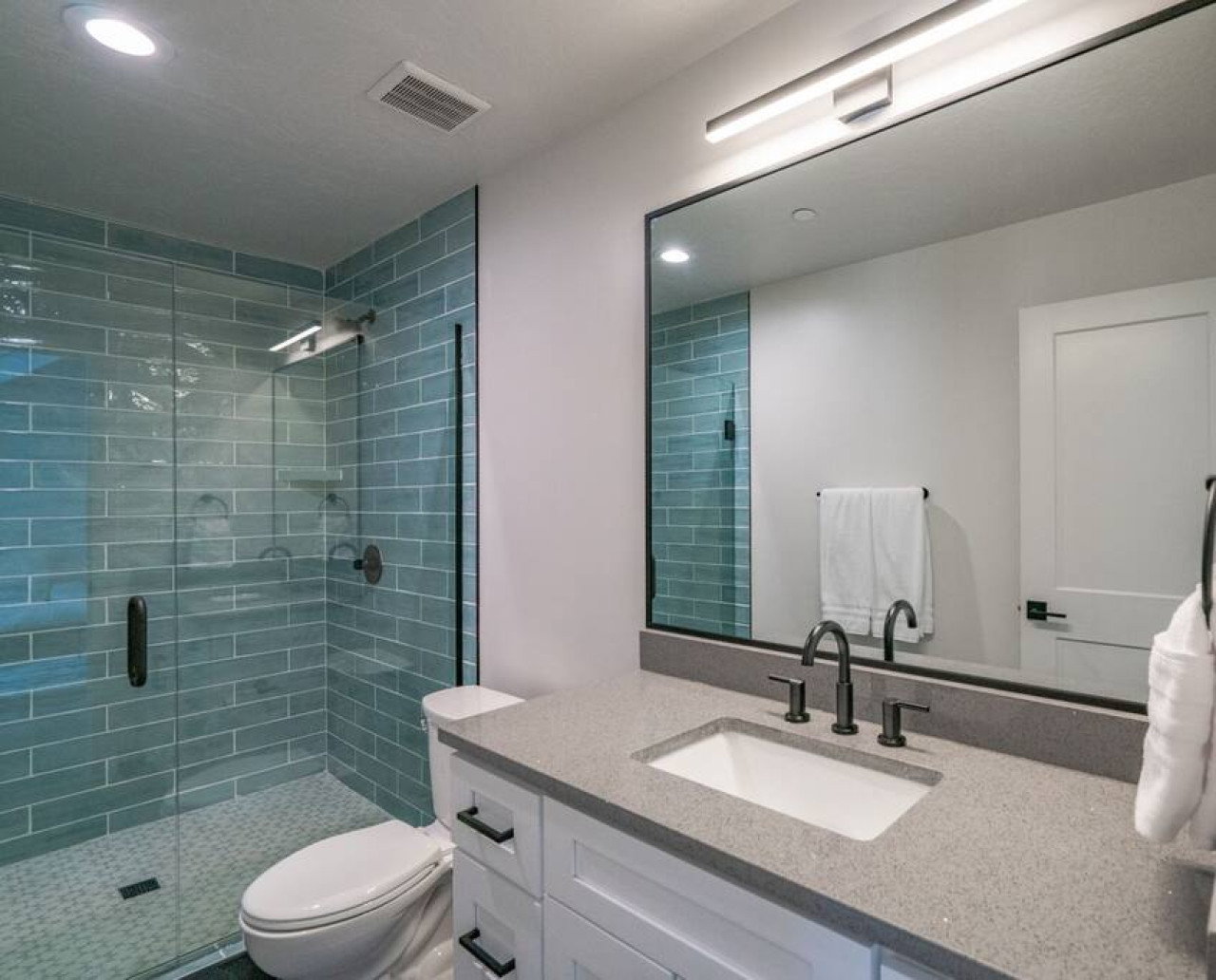 Bathroom featuring vanity, recessed lighting, and a stall shower