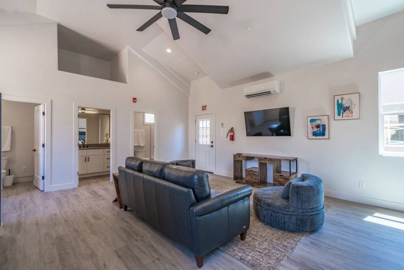 Living area featuring a ceiling fan, light wood finished floors, vaulted ceiling, and recessed lighting