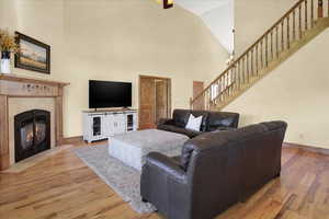 Living area with light wood finished floors, a fireplace, and vaulted ceiling