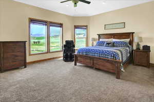 Master Bedroom featuring light colored carpet, multiple windows, a ceiling fan, and a mountain view
