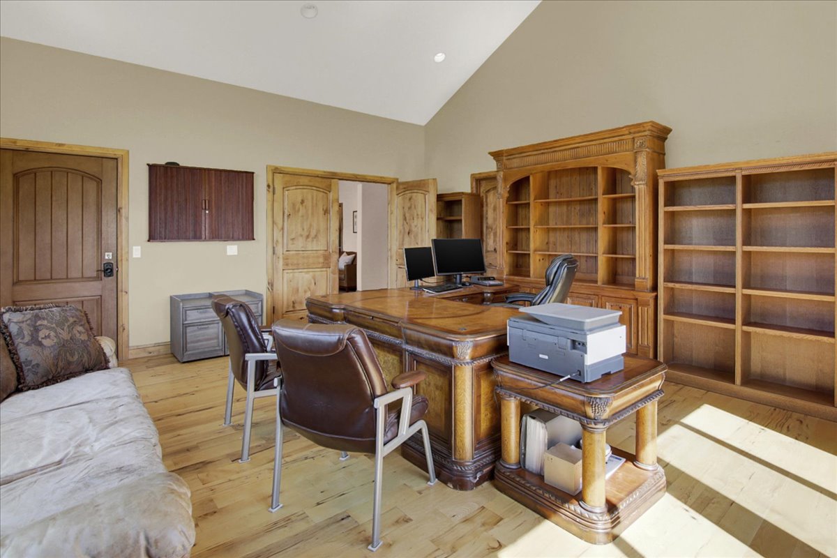 Main Office with direct access from front porch.  Featuring light wood-type flooring and vaulted ceiling