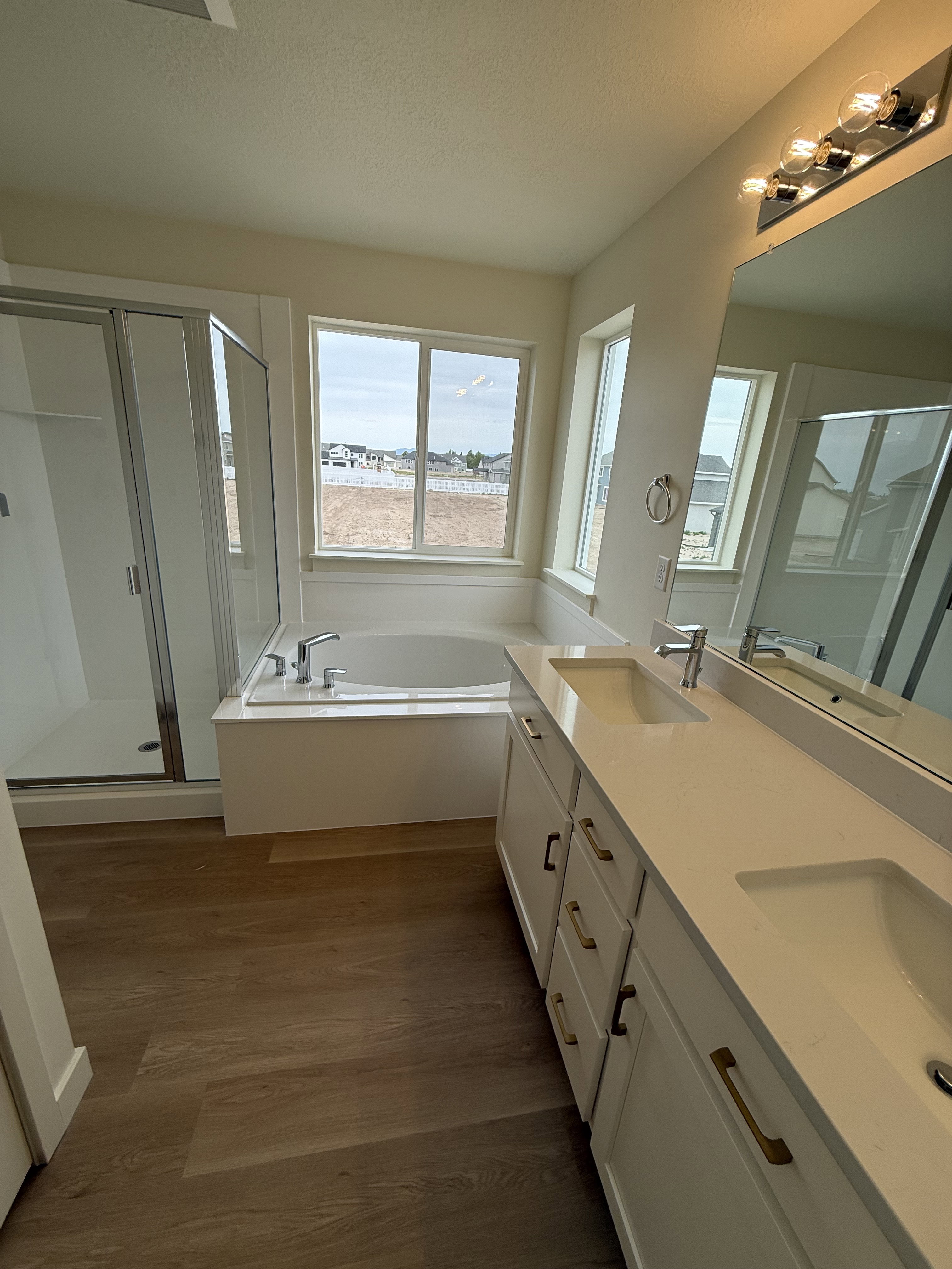 Dual vanity featuring white cabinetry, integrated sinks, and brushed gold hardware