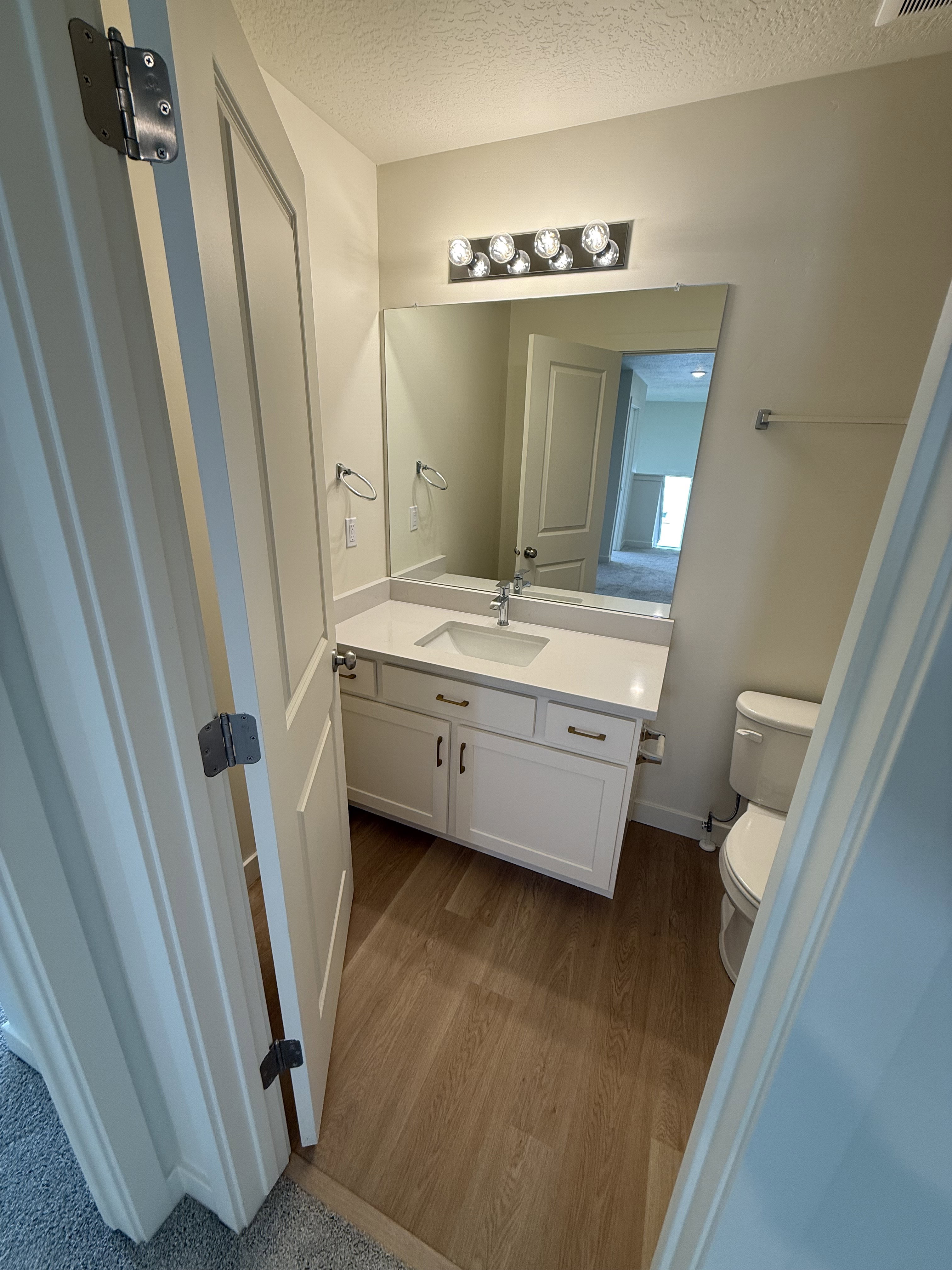 Bathroom featuring a vanity with white cabinetry, light-toned countertop, and undermount sink