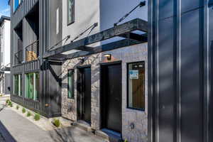 Entrance to property featuring stone siding