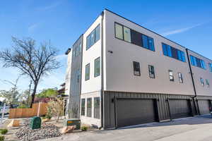 View of property exterior featuring a garage, stucco siding, driveway, and board and batten siding