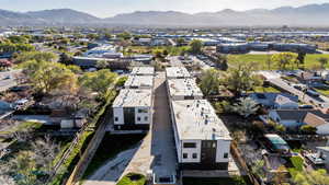 Aerial view of property and surrounding area featuring a mountainous background and nearby suburban area