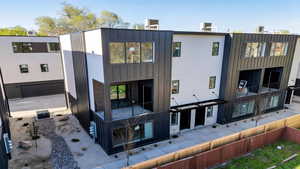 Rear view of property with board and batten siding and a balcony