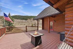 Wooden terrace with a fire pit and a forest view
