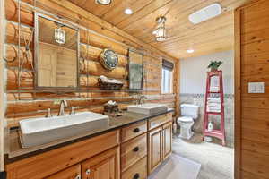 Bathroom featuring a wainscoted wall, double vanity, and recessed lighting