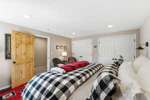 Bedroom featuring two closets, recessed lighting, and carpet