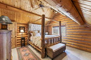 Bedroom featuring light colored carpet, log walls, lofted ceiling with beams, and wood ceiling