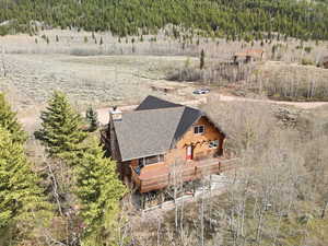 Aerial view of property and surrounding area featuring a forest