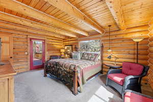 Bedroom with light carpet, access to exterior, log walls, and a wood ceiling with exposed beams