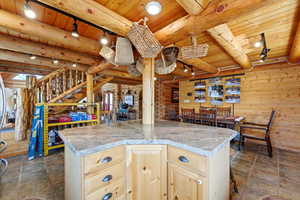 Kitchen with rustic walls, rail lighting, light wood finish cabinetry, a wood ceiling with exposed beams, and light countertops