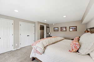 Bedroom with carpet flooring, multiple closets, and recessed lighting