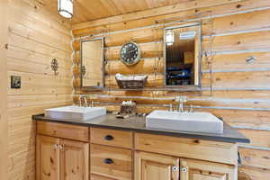 Bathroom with wooden walls and double vanity