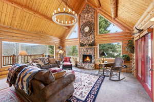 Living area featuring carpet, log walls, suspended lighting, a high wooden beamed ceiling, and a fireplace