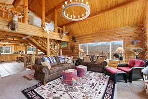 Living area with log walls, a high wooden beamed ceiling, and light tile patterned floors