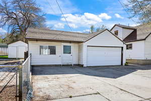 View of front of home with roof with shingles and driveway