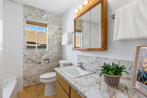 Bathroom with vanity, a tub, and tasteful backsplash