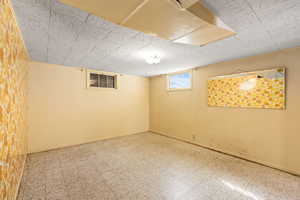 Below grade area with baseboards and tile patterned floors