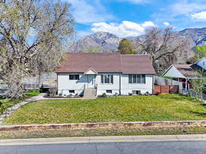 View of front of property featuring a mountain view, a shingled roof, and entry steps