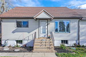 View of front of house with a shingled roof