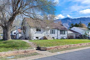 View of front facade with a front lawn and a mountain view