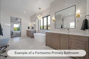 Ensuite bathroom with two vanities, a freestanding tub, and hanging lights