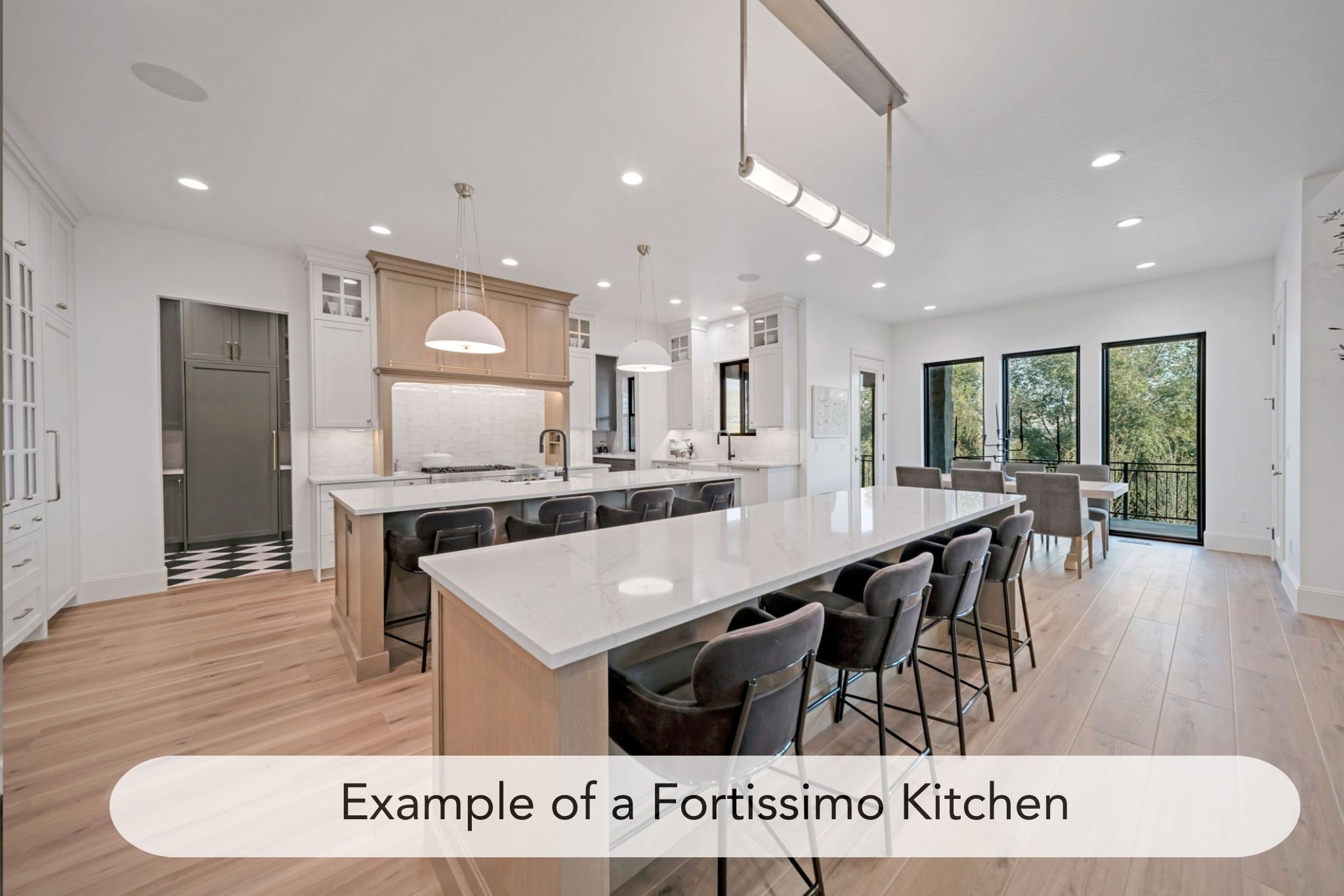 Dual tone kitchen featuring dual tone cabinets, glass fronted cabinets, light stone countertops, light wood finished floors, and a kitchen breakfast bar