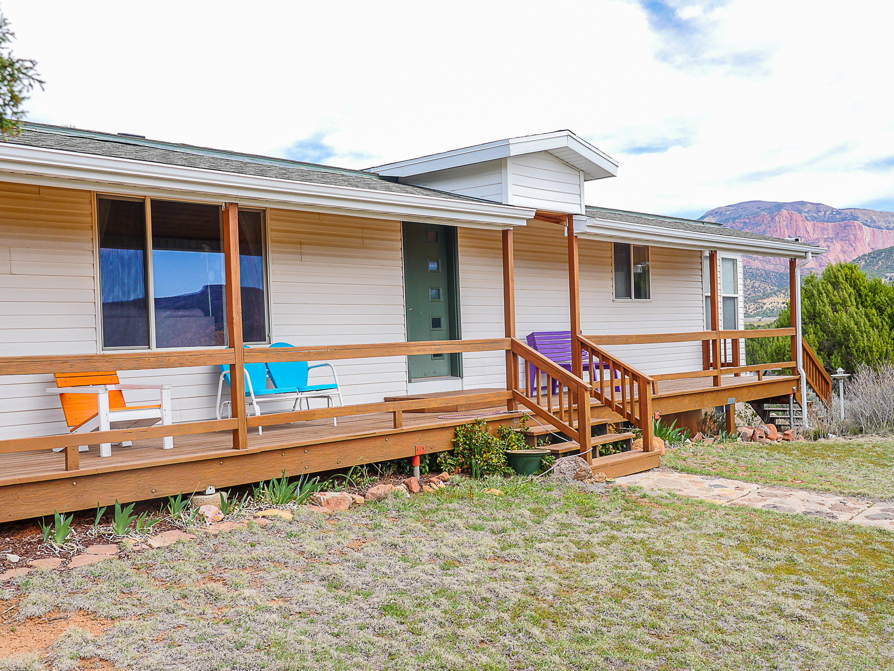 View of front of home featuring a front lawn, roof with shingles, and a mountain view
